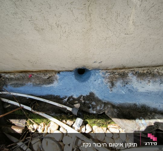 חור בקיר עם חומר איטום כחול סביבו